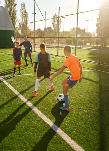 young-boys-playing-football-soccer-match-at-training-camp-for-kids.jpg